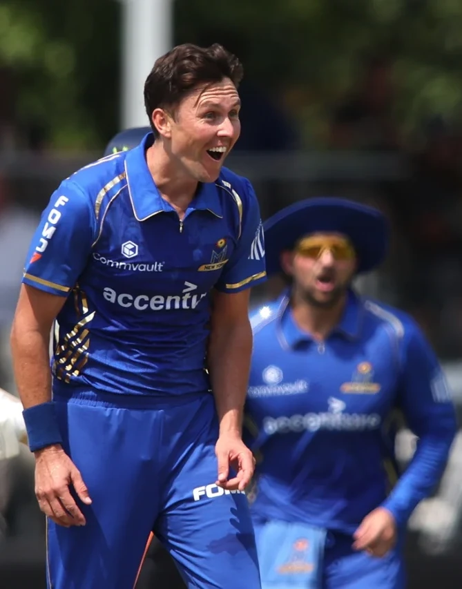 Cricketer in blue Mumbai Indians New York jersey with FOMO7 India branding celebrating on the field.